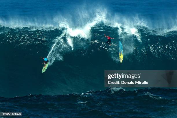 One surfer rides the wave while another wipes out during the Eddie Aikau Big Wave Invitational on January 22, 2023 in Waimea Bay, Haleiwa, Hawaii....