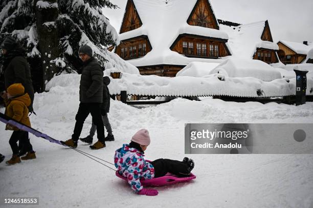 People enjoy their time in the city center covered in snow after snowfall in Zakopane, Poland on January 22, 2023. After unusually warm weather...