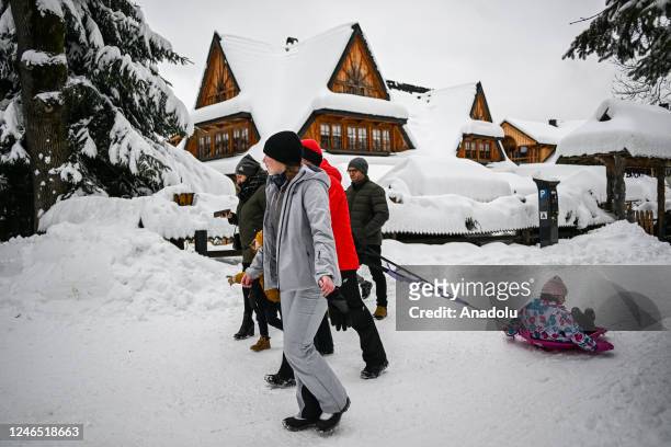 People enjoy their time in the city center covered in snow after snowfall in Zakopane, Poland on January 22, 2023. After unusually warm weather...
