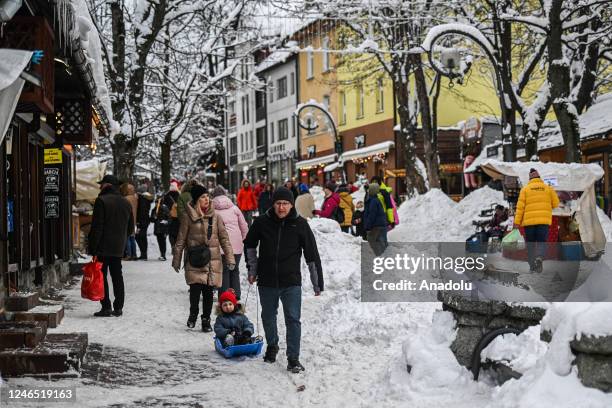 People enjoy their time in the city center covered in snow after snowfall in Zakopane, Poland on January 22, 2023. After unusually warm weather...