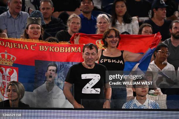 Man wearing a "Z" T-shirt watches the men's singles quarter-final match between Serbia's Novak Djokovic and Russia's Andrey Ruble, next to supporters...