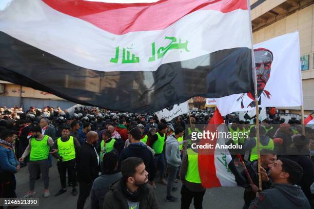 Iraqi people gather near the Central Bank building to stage a protest against depreciation of the dinar against the US dollar in Baghdad, Iraq on...
