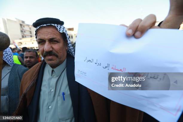 Iraqi people gather near the Central Bank building to stage a protest against depreciation of the dinar against the US dollar in Baghdad, Iraq on...