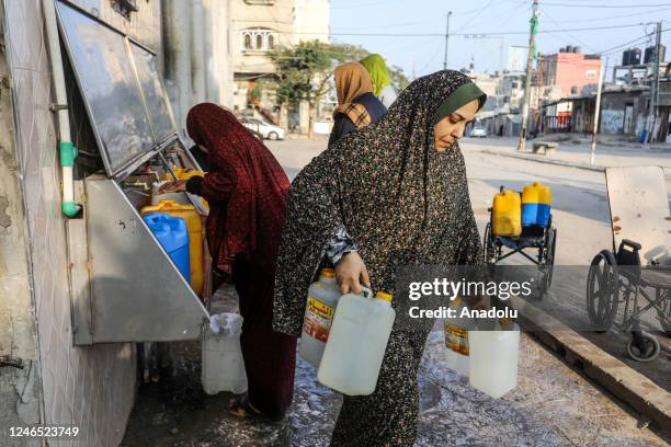 Palestinians fill up a fountain constructed by charitable organizations and take it to their homes due to the poor quality of the water supply in...