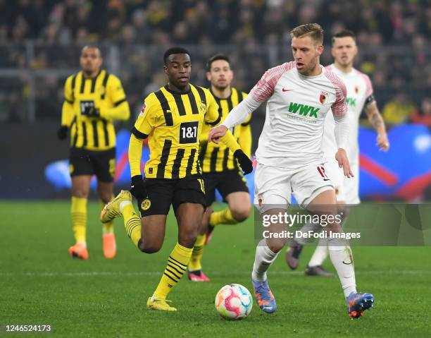 Youssoufa Moukoko of Borussia Dortmund and Arne Maier of FC Augsburg battle for the ball during the Bundesliga match between Borussia Dortmund and FC...