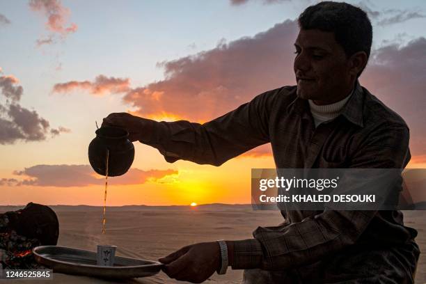 Ahmed el-Masri, a desert guide and driver, serves tea at sunset during a safari trip in the vicinity of Egypt's western desert oasis of Siwa, about...