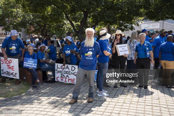 Supporters of the largest opposition party 'Democratic Alliance' hold banners and gather to protest against the ruling party 'African National...