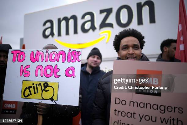Amazon workers hold GMB union placards on the picket line as they hold a strike outside the Amazon fulfilment centre on January 25, 2023 in Coventry,...