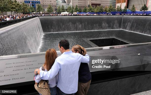 Family members gather at the edge of the North Pool of the 9/11 Memorial during the tenth anniversary ceremonies of the September 11, 2001 terrorist...
