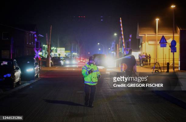 Police officers secure the area near the train station in Brokstedt, northern Germany, on January 25 after two people were killed and several others...