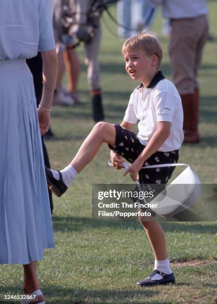 Prince William playing with a handbag during the Cartier International Polo event at Smith's Lawn, Windsor Great Park on 23rd July 1989.