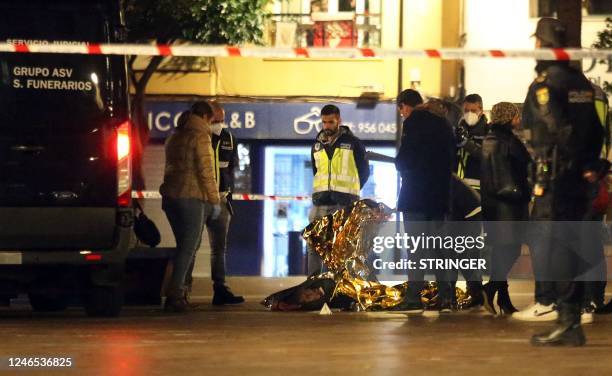 Graphic content / Police and rescuers work next to the body of a man killed in Algeciras, southern Spain, on January 25, 2023. - Spain opened a...