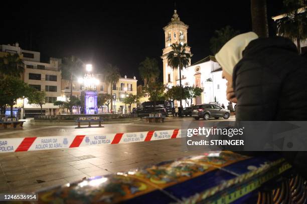 Man observes police and rescuers working on the site where a man was killed in Algeciras, southern Spain, on January 25, 2023. - Spain opened a...