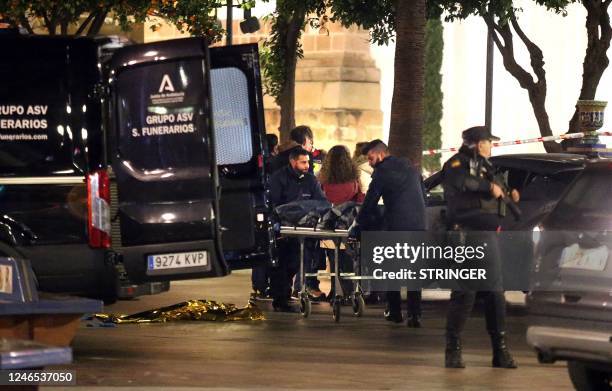 Police and rescuers carry the body of a man killed in Algeciras, southern Spain, on January 25, 2023. - Spain opened a terror probe on January 25...