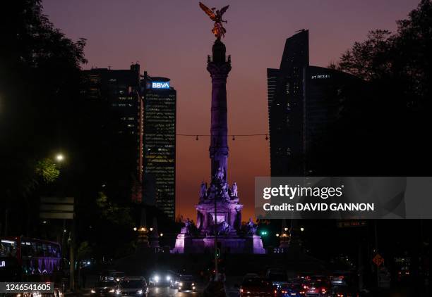 The sun sets behind the Angel of Independence monument in Mexico City on January 25, 2023.