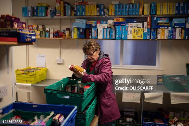 Worker at the Coventry Foodbank centre in Queens Road Baptist Church collates donated food items into parcels that will be provided to people...