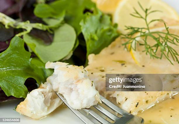 white fish fillet in lemon and herbs sauce - hake stock pictures, royalty-free photos & images