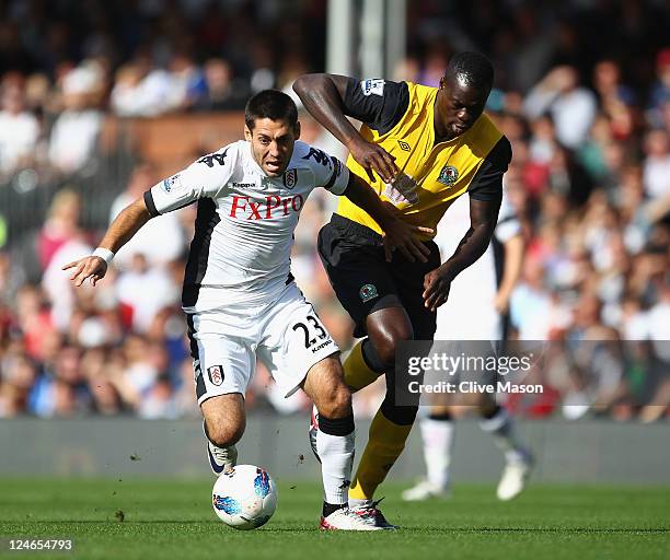 Clint Dempsey of Fulham holds off a challenge from Christopher Samba of Blackburn Rovers during the Barclays Premier League match between Fulham and...