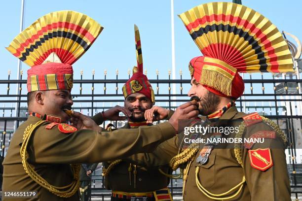 Indian Border Security Force soldiers pose while offering sweets to each other during the celebrations to mark country's Republic Day at the...