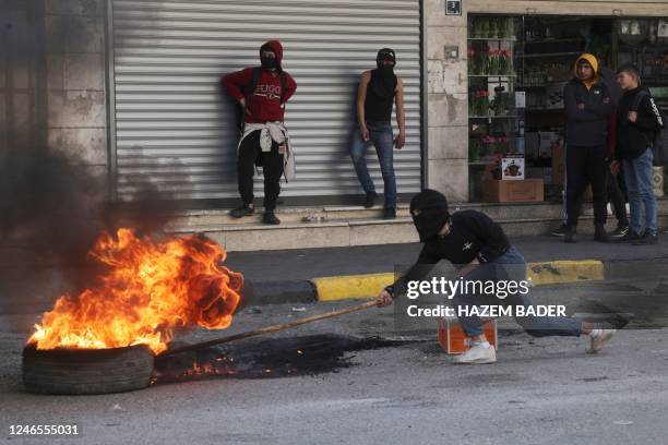 Palestinian protesters set tyres on fire during clashes with Israeli forces following protests against the expropriation of Palestinian land in...