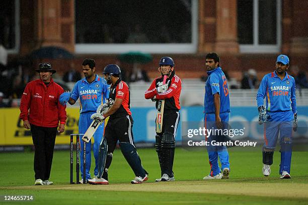 Umpire Richard Illingworth, RP Singh of India, Ravi Bopara of England, Graeme Swann, Munaf Patel and MS Dhoni look on before leaving the field after...