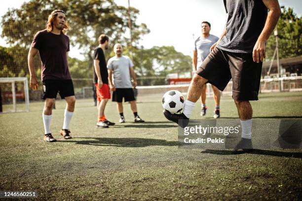 equipo de fútbol masculino amateur jugando al fútbol al aire libre - entrenamiento deportivo fotografías e imágenes de stock