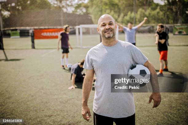 portrait of mid adult men on soccer field - amateur stock pictures, royalty-free photos & images