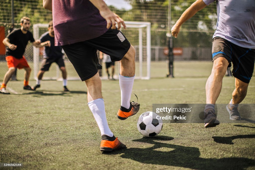 Mannelijke voetballer die voetbalbal schopt