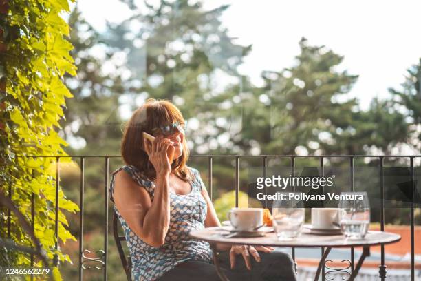 woman talking on the phone during breakfast - moving down to seated position stock pictures, royalty-free photos & images