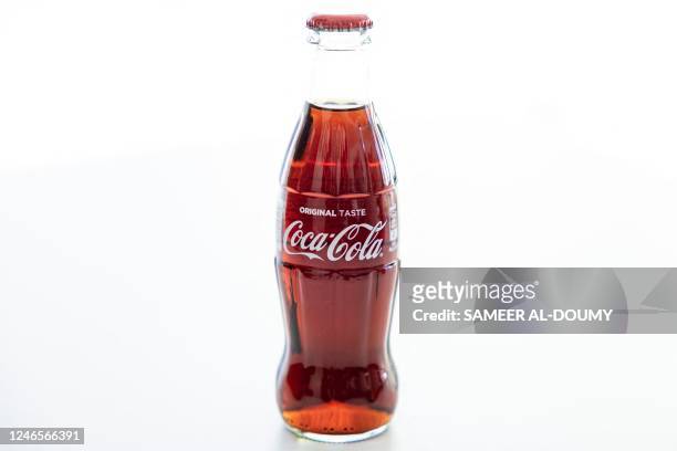 This photograph taken on January 26, 2023 shows samples of Cola's bottles at the Coca Cola factory in Bierne, northern France. - The CCEP group,...