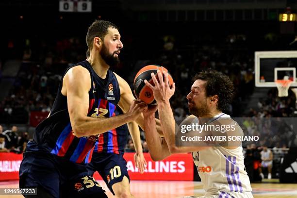 Barcelona's Spanish forward Nikola Mirotic fights for the ball with Real Madrid's Spanish guard Sergio Llull during the Euroleague Basketball match...