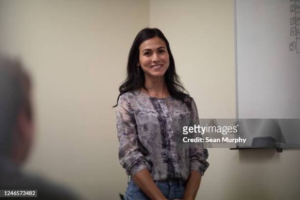 Young latino woman smiling at camera during business meeting.