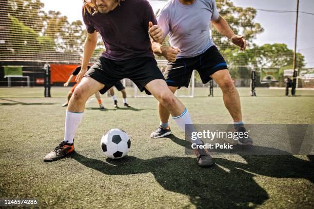 amateur-fußballmannschaft spielt fußball im freien - torschuss stock-fotos und bilder