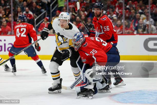 Darcy Kuemper of the Washington Capitals has his helmet knocked off after a collision with Teddy Blueger of the Pittsburgh Penguins during a game at...