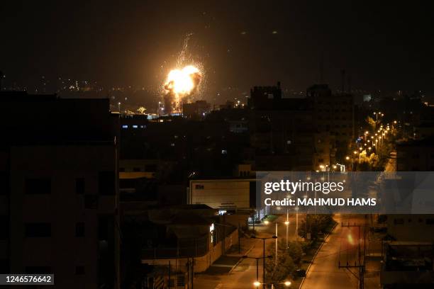 Fire and smoke rise above buildings in Gaza City as Israel launched air strikes on the Palestinian enclave early on January 27, 2023. - Israel...