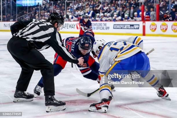 Mark Scheifele of the Winnipeg Jets and Tyson Jost of the Buffalo Sabres get set to take a second period face-off at the Canada Life Centre on...