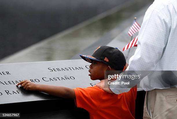 Young mourner touches the names of the lost loved ones during tenth anniversary ceremonies of the September 11, 2001 terrorist attacks at the World...