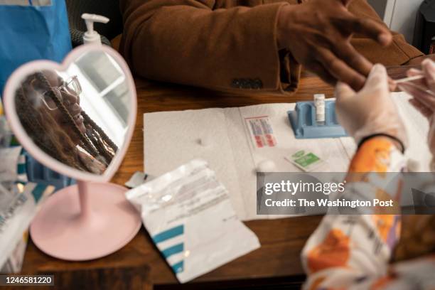 Kayla Collins, director of health and wellness, is reflected while preparing an HIV test Josh Hall, director of youth emergency services, at...