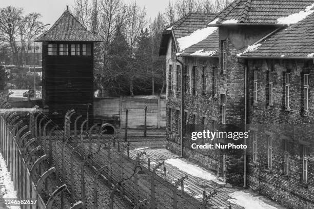 Image was converted to black and white) A watchtower and barb wired fence at the former Nazi German Auschwitz I concentration camp at Auschwitz...