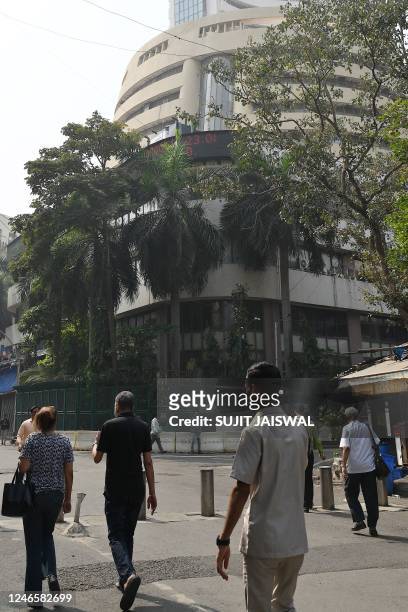 Pedestrians walk past the Bombay Stock Exchange building in Mumbai on January 27, 2023. - Trading in the business empire of Asia's richest man Gautam...