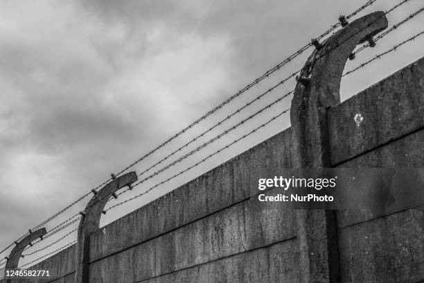 Image was converted to black and white) Barb wired fence at the former Nazi German Auschwitz I concentration camp at Auschwitz Memorial Site a day...