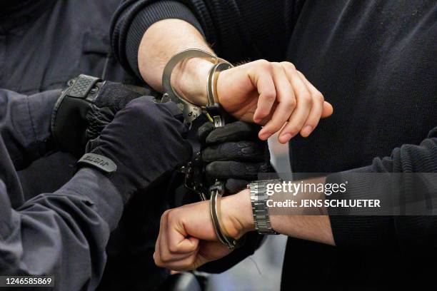 Defendant is led in handcuffs by judicial officers into the courtroom of the Higher Regional Court in Dresden, eastern Germany on January 27, 2023...