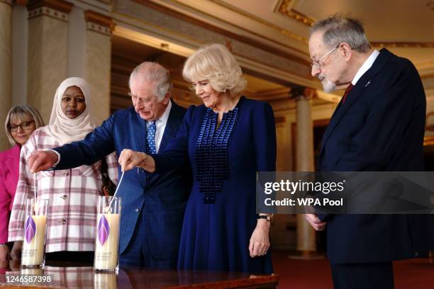 King Charles III and Camilla, Queen Consort light a candle at Buckingham Palace to mark Holocaust Memorial Day alongside Holocaust survivor Dr Martin...