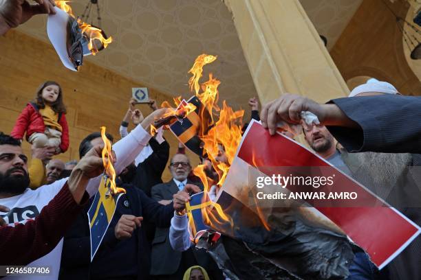 Lebanese burn Swedish flags during a protest outside the Mohammed al-Amin Mosque in Beirut on January 27, 2023 against the burning of a Koran in...