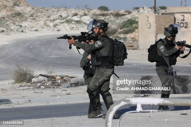 Israeli troops aim their weapons during confrontations with Palestinian demonstrators in the West Bank town of Al-Ram on January 27 a day after a...