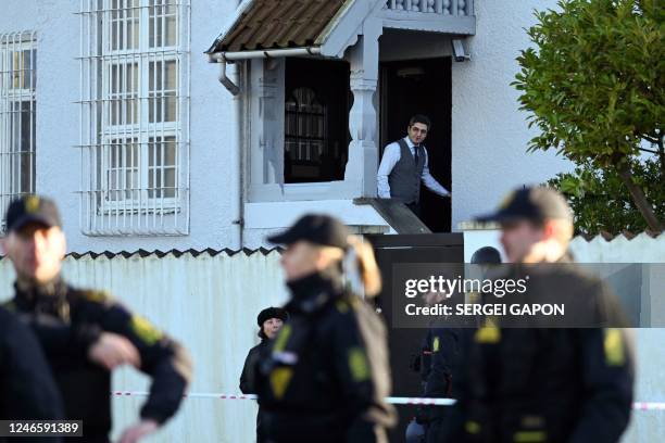 Man looks out of the Turkish embassy as police secure the area in front of the Turkish embassy in Copenhagen, on January 27, 2023. - Turkey summoned...