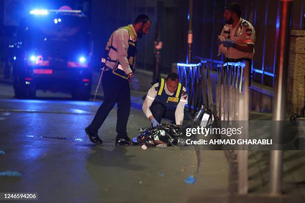 Graphic content / Israeli emergency service personnel rush near casualties at the site of a reported attack in a settler neighbourhood of...