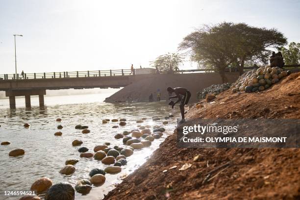 Man washes his clothes in the Niger river in Niamey, on January 27, 2023.