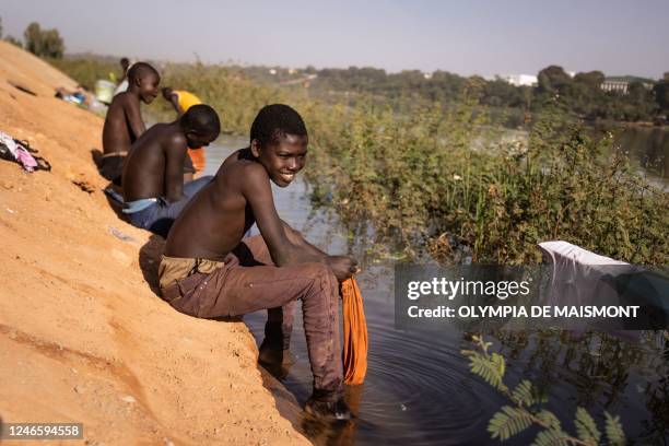 Boys wash their clothes in the Niger river in Niamey, on January 27, 2023.