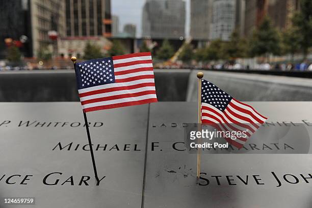 Small flags are left on the bronze plaques that bear the names of the victims of the September 11 terror attacks that surround the perimeter of the...